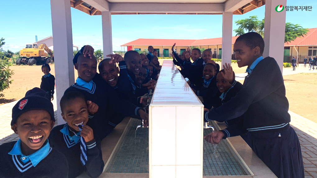 수돗가에서 손을 씻는 신기다 학생들.jpg