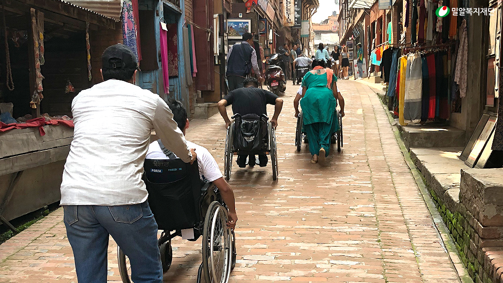 휠체어로 이동하고 있는 VOICE 직업훈련센터 훈련생들.jpg