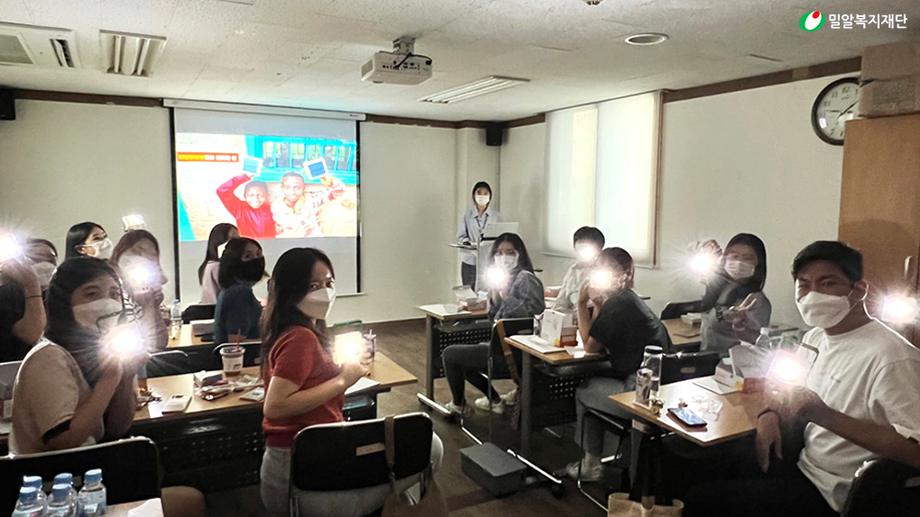 다함께 태양광 랜턴을 들고 있는 대학생 봉사단.jpg