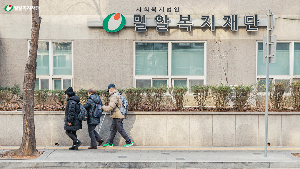 밀알복지재단 헬렌켈러센터 앞, 걷고 있는 시청각장애인과 활동지원사.jpg