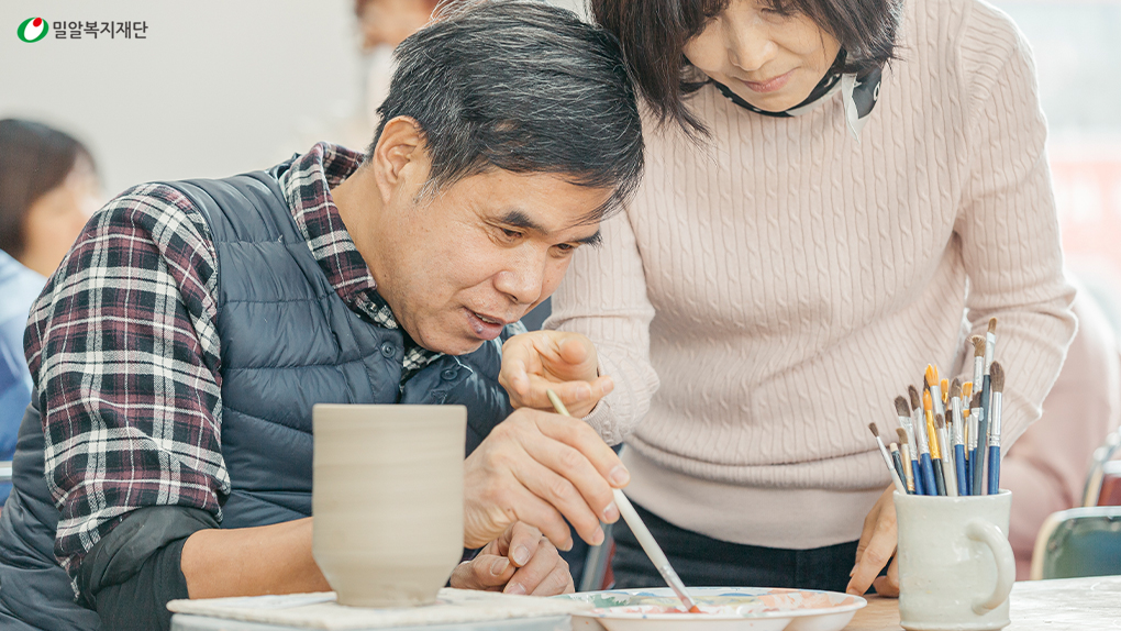 도자기 그릇에 그림을 그리고 있는 시청각장애인과 활동지원사(1).jpg