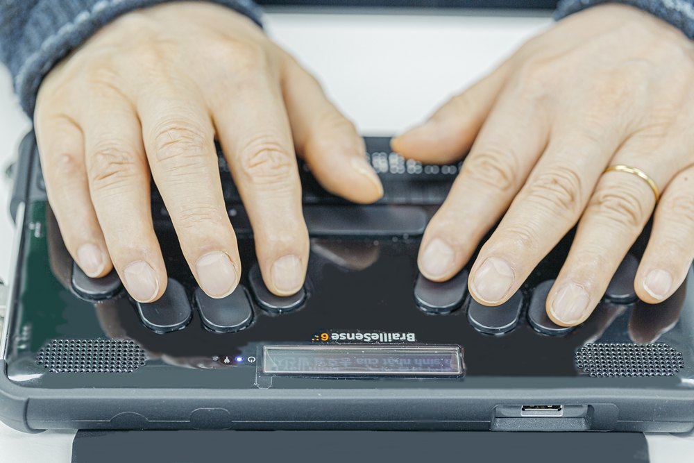 점자정보단말기를 사용하고 있는 시청각장애인의 손.jpg