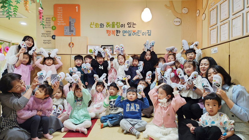 아동화를 선물 받고 즐거워하는 면일어린이집 아동들.png